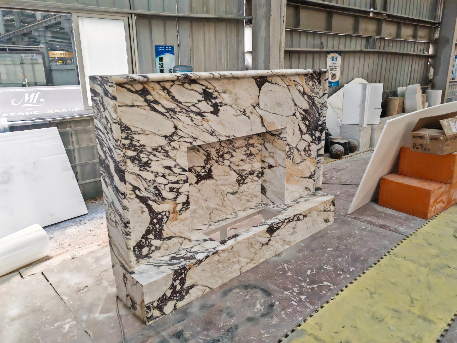 Monumental Calacatta Viola marble fireplace surround with dramatic purple and ochre veining, photographed in the workshop