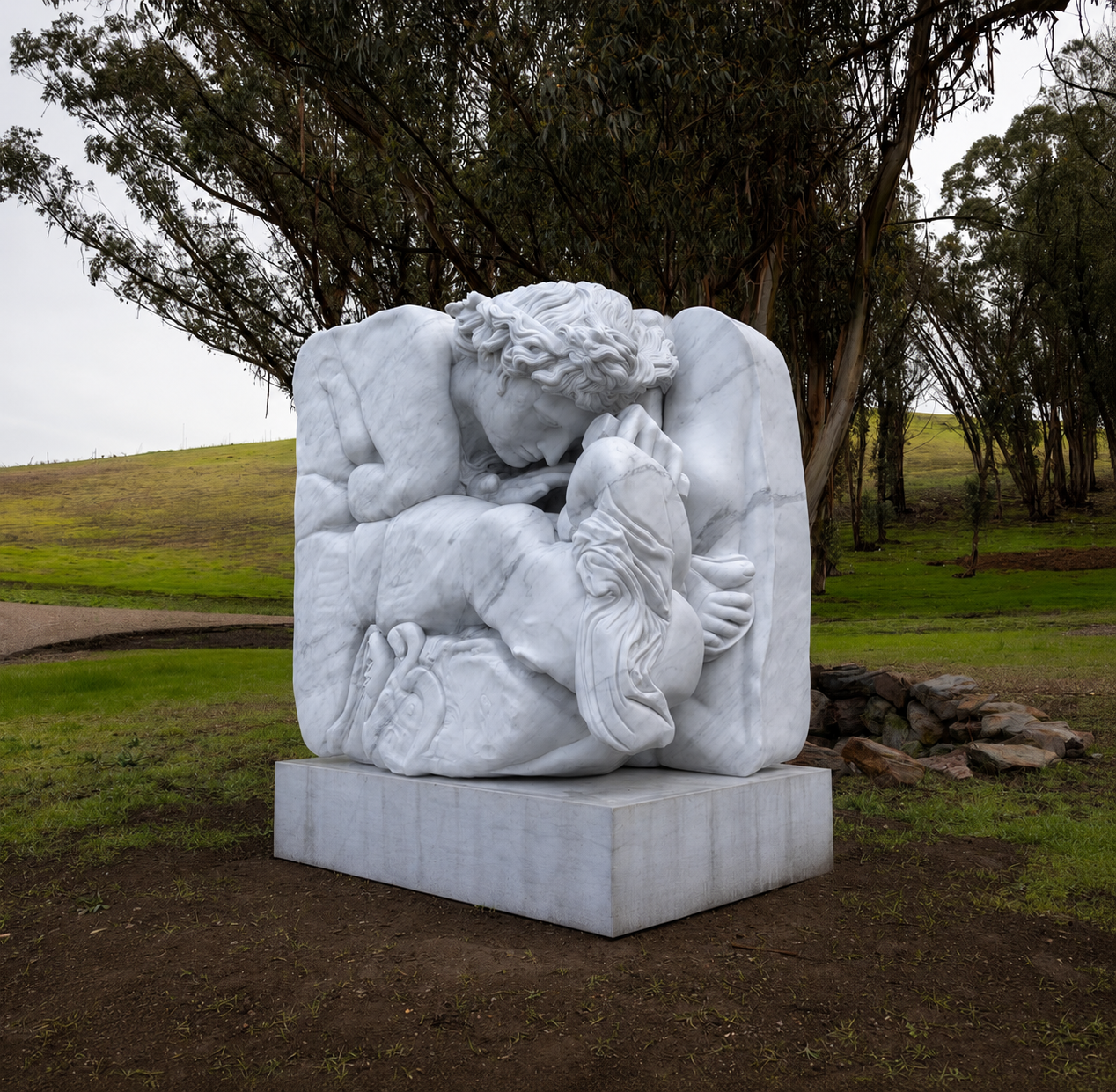 Monumental Carrara marble sculpture of two intertwined sleeping figures on a concrete plinth, set under eucalyptus trees in a rolling landscape