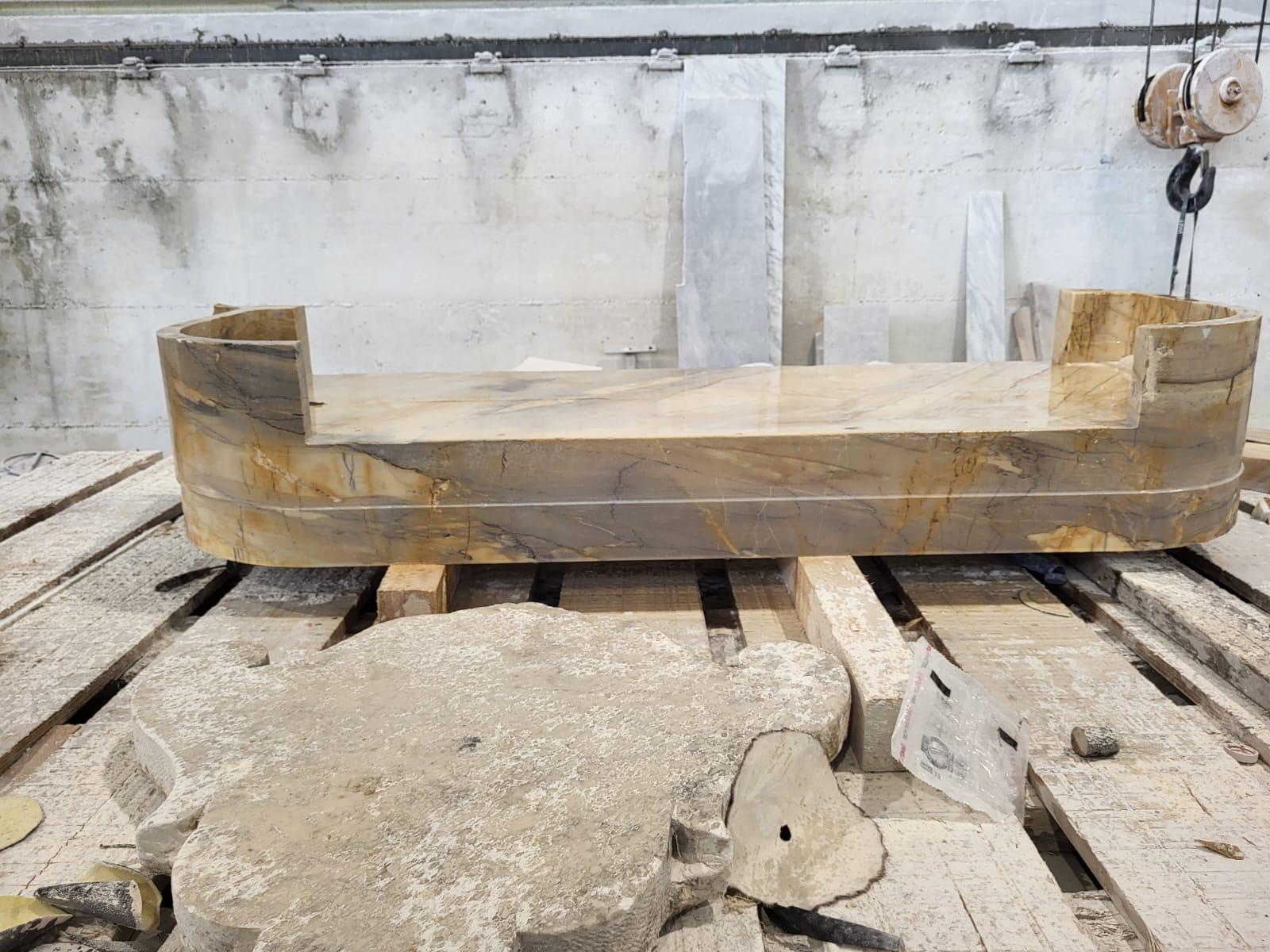 Long polished vessel in honey-amber Siena marble with grey veining, raised ends, in the workshop