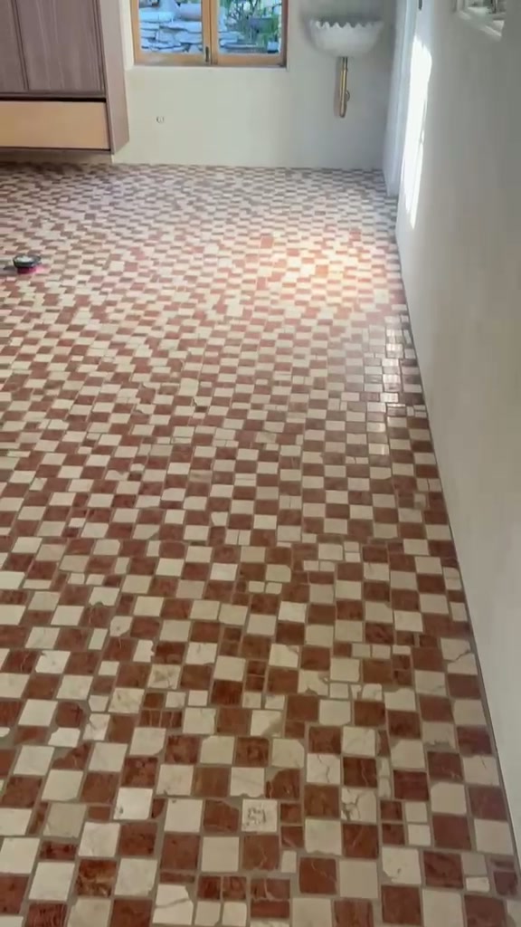 Interior room with a hand-laid red and cream checkerboard marble mosaic floor, panning through to terracotta hex tiles