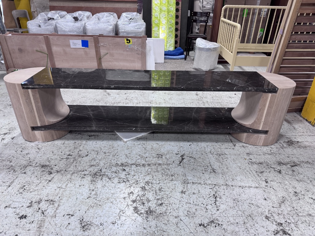 Long dark marble bench supported by two cylindrical oak legs, photographed head-on in the workshop