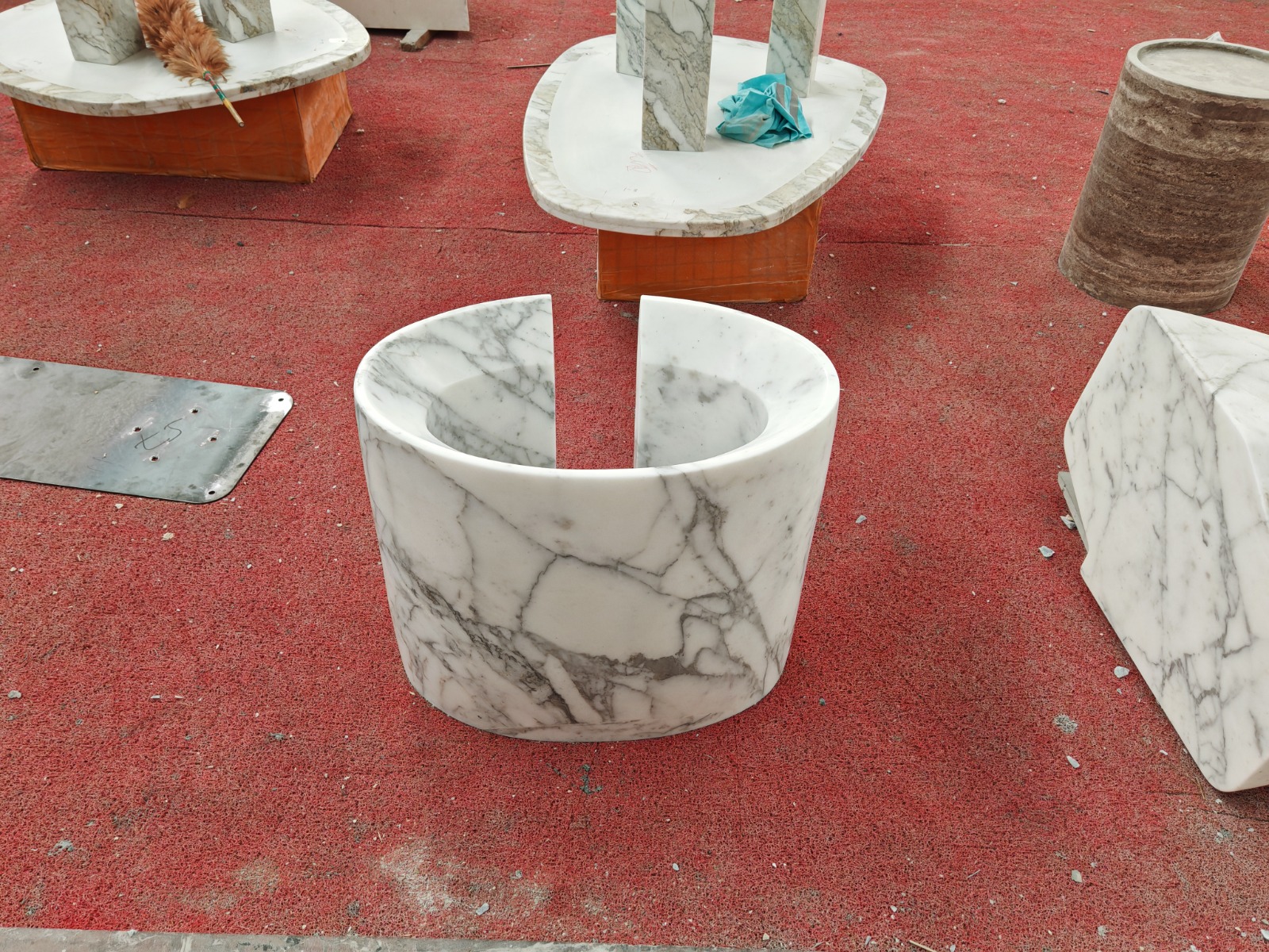 Carrara marble vessel split vertically into two halves, revealing a carved interior