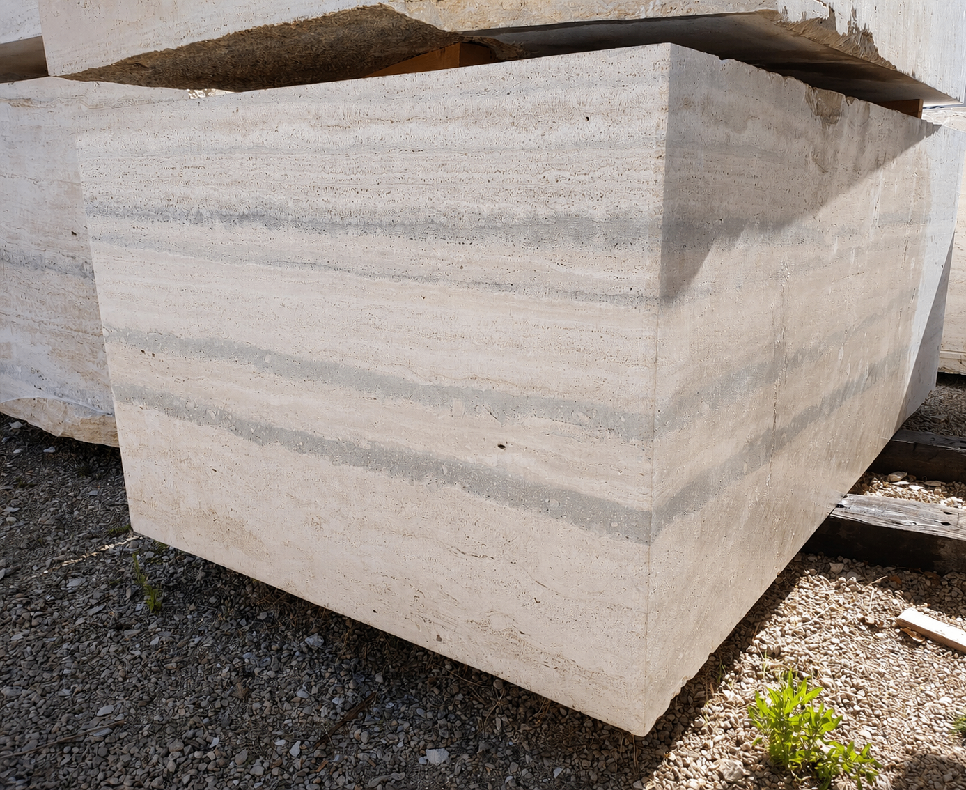 Large squared block of Silver Travertine showing linear grain and a distinctive band of darker grey striations