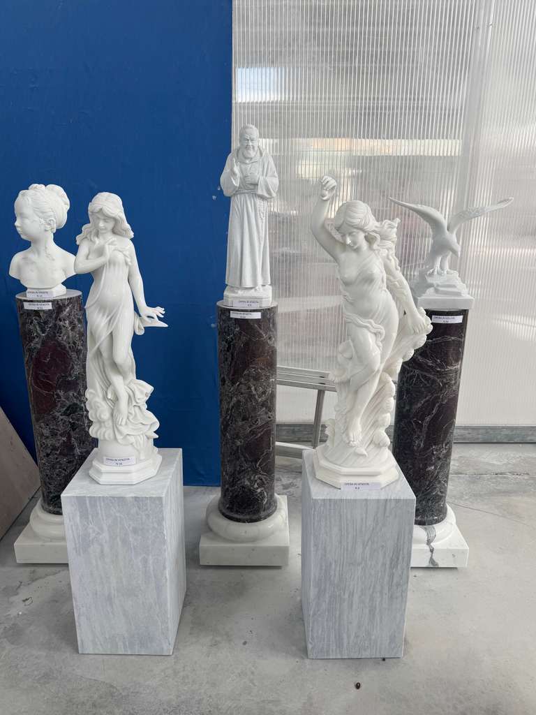 Group of small classical marble figures and busts displayed on tall Rosso Levanto marble columns