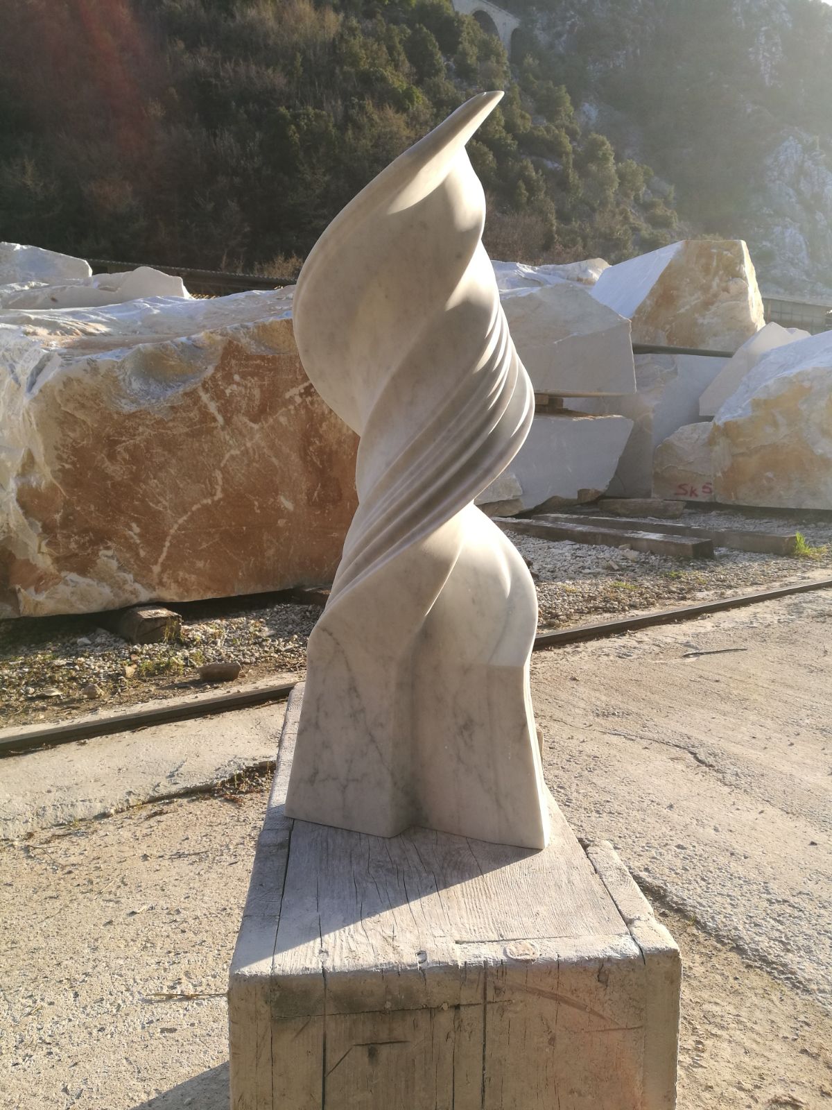 Tall white Carrara marble flame sculpture in the quarry
