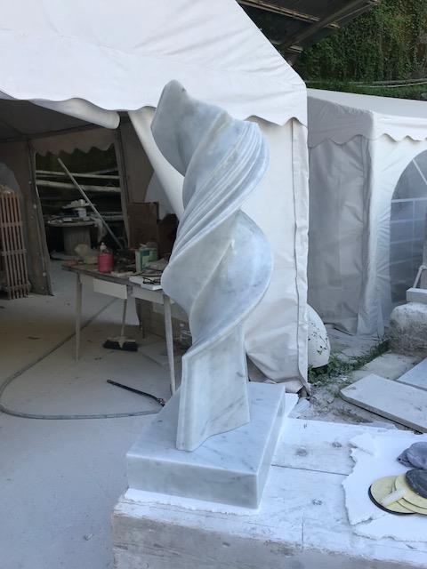 White Carrara marble twisted spiral sculpture in the workshop tent