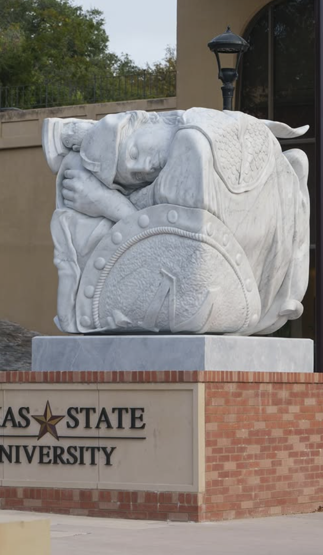 Monumental white marble sleeping warrior cube sculpture at Texas State University